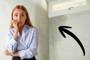 persona preoccupata e dietro un muro umido indicato da una freccia