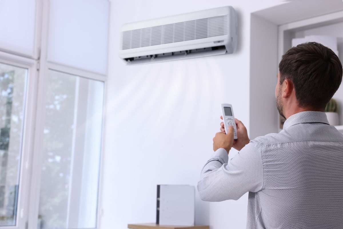 uomo usa condizionatore che emana aria fredda