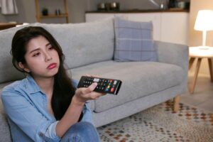 donna scocciata mentre guarda tv