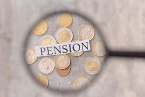 monete, scritta pensione e lente ingrandimento
