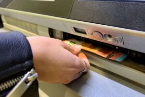 persona che preleva soldi dal bancomat