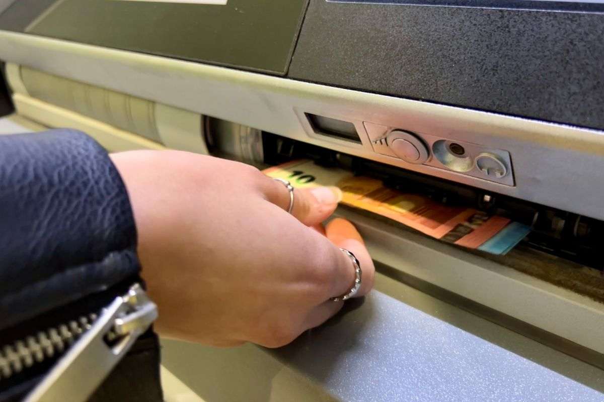 persona che preleva soldi dal bancomat
