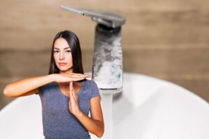 donna che dice stop al calcare sui rubinetti