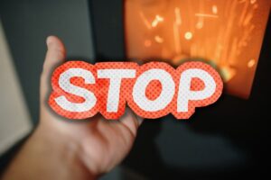 mano con pellet, stufa e scritta stop