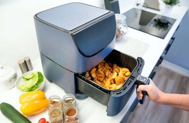 donna che usa friggitrice ad aria per cucinare