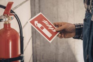 uomo che controlla etichetta estintore
