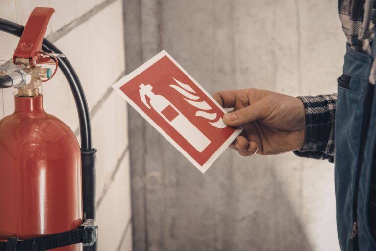 uomo che controlla etichetta estintore