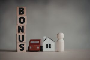 scritta bonus con modellino in legno di auto, casa e persona