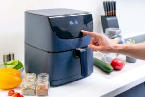 mano che accende friggitrice ad aria